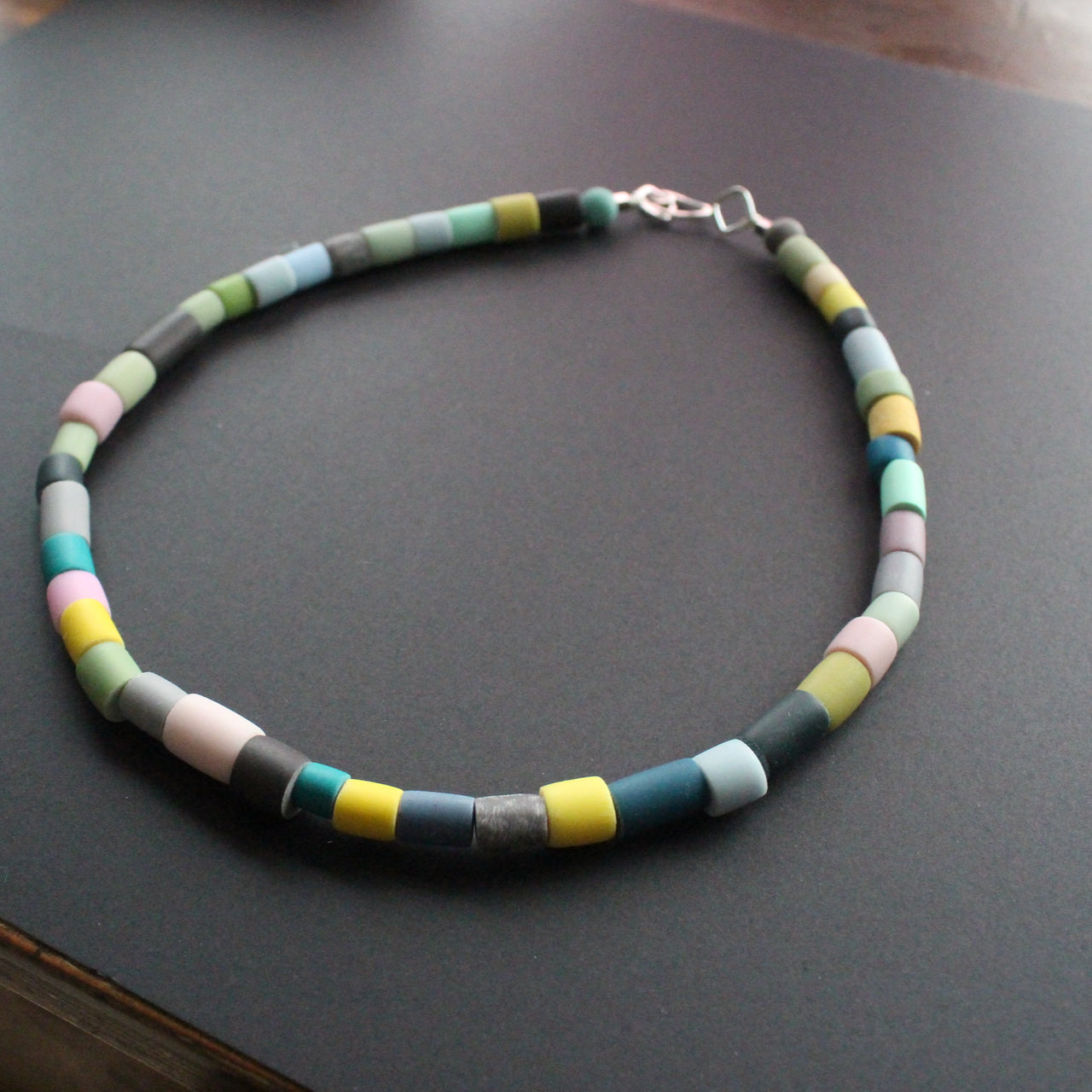Tube bead polymer clay necklace in muted earth colours by UK artist Clare Lloyd