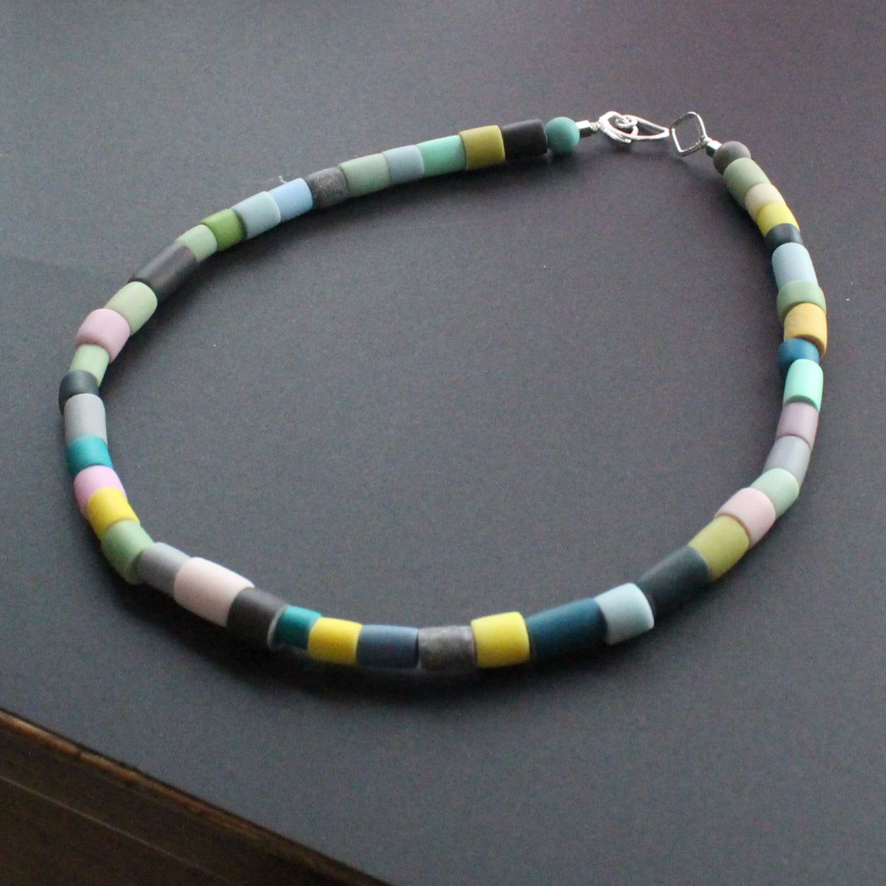 Tube bead polymer clay necklace in muted earth colours by artist Clare Lloyd