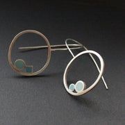Round drop earrings with 2 dots of turquoise and aqua sitting inside the rings by UK artist Clare Lloyd