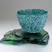 Sea blue heavily textured glass vessel sitting on slate by artist Caroline Reed