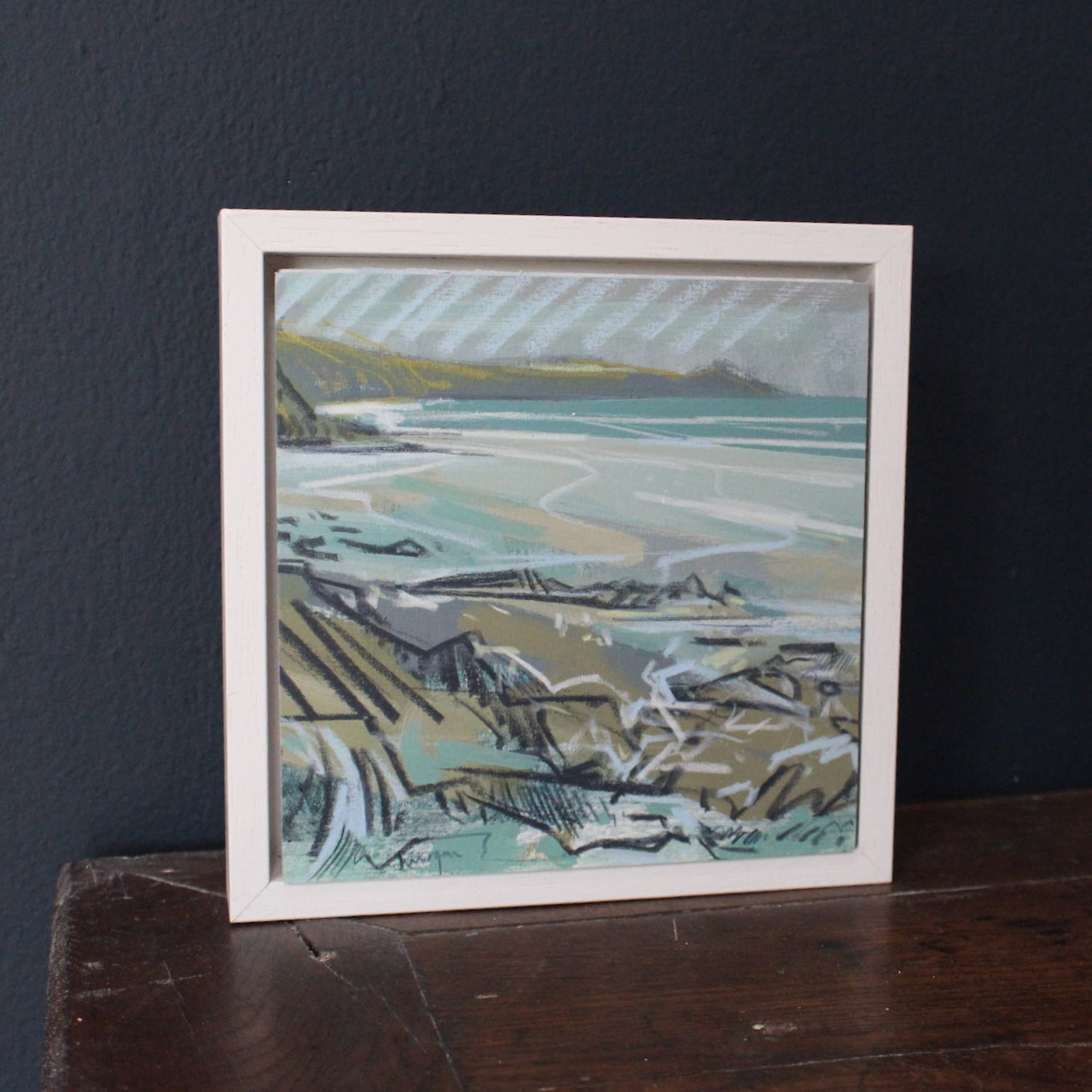 small seascape by Imogen Bone, Cornish artist. The cliffs are green, ochre and black and the sea is pale blue with hints of white and turquoise