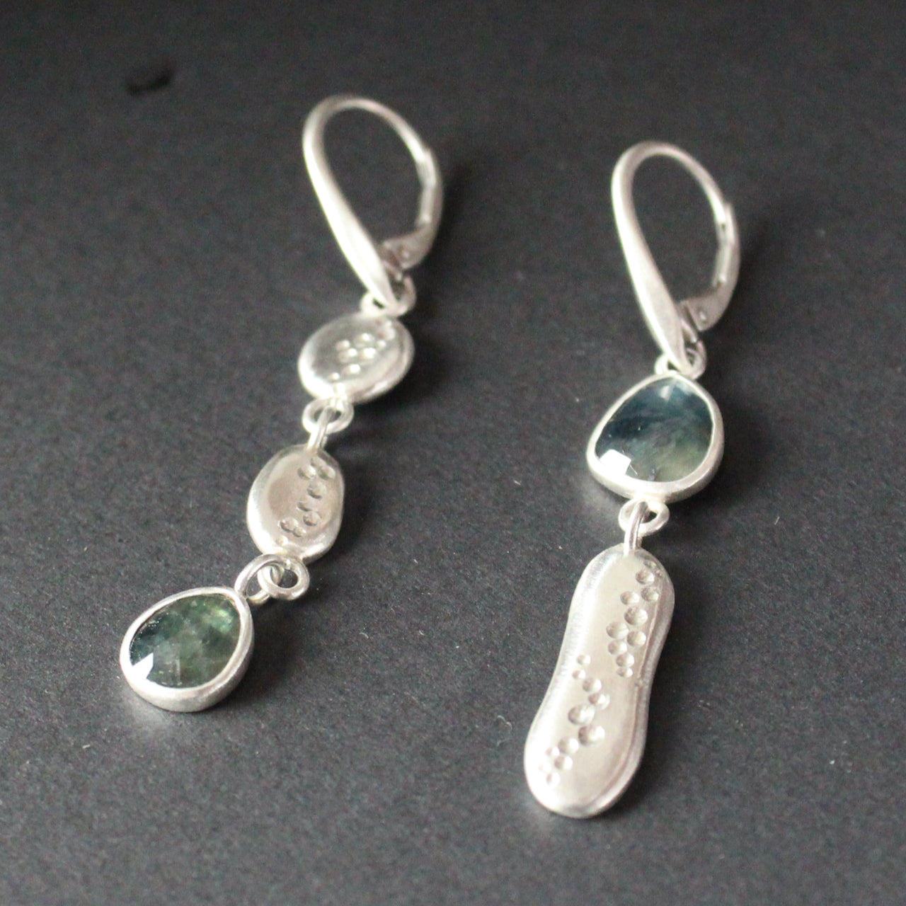 Carin Lindberg silver and teal sapphire drop earrings the sapphire is an a different position on each earring