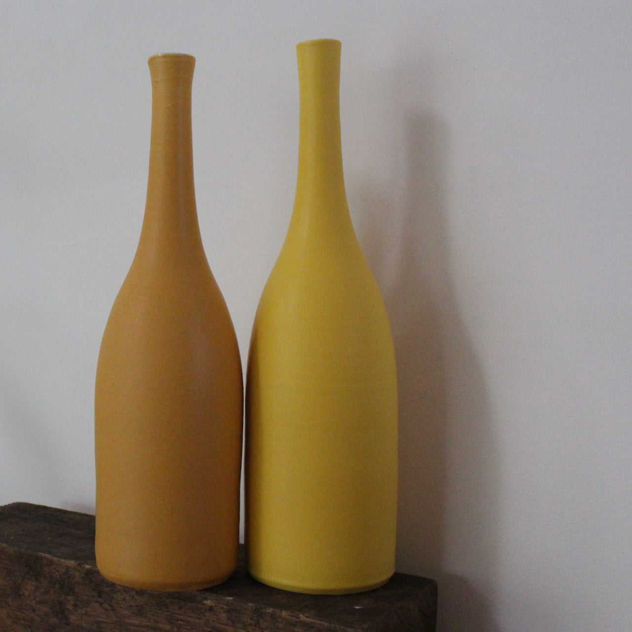 two yellow ceramic bottles by UK ceramicist Lucy Burley
