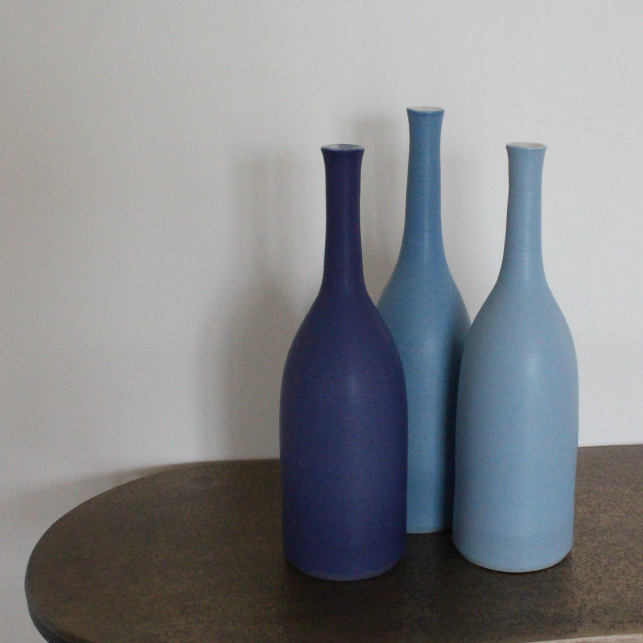 a trio of blue ceramic bottles by ceramic artist Lucy Burley