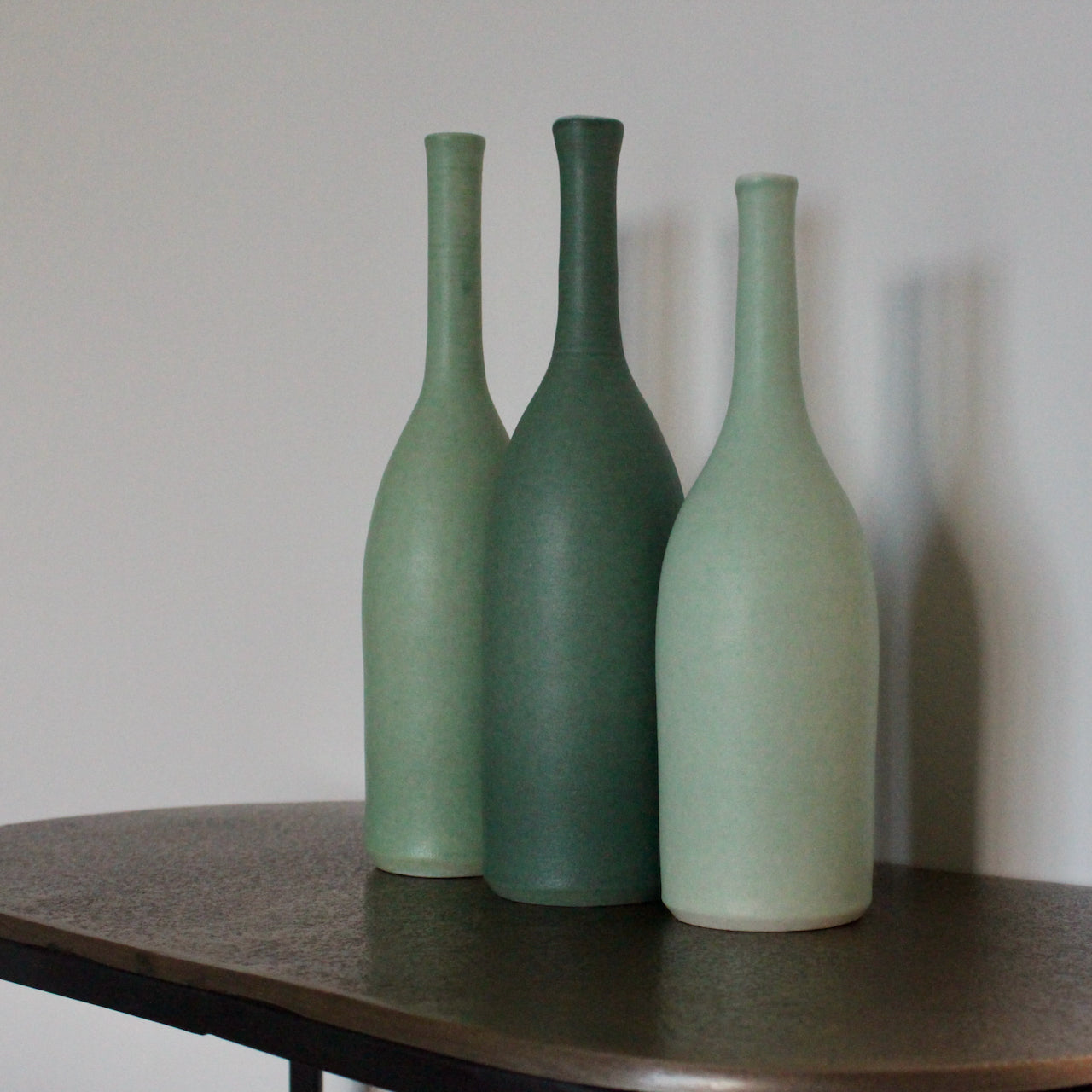 Three ceramic bottles by Lucy Burley in shades of green