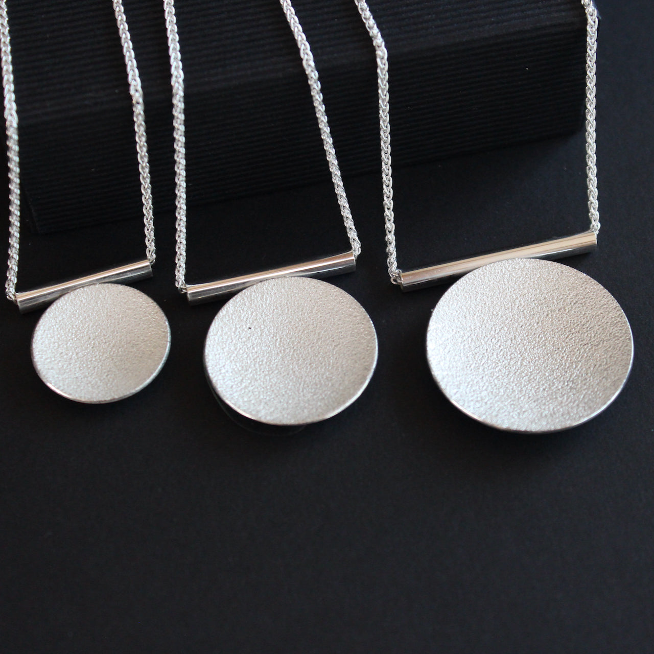 three Textured silver round pendants by Beverly Bartlett 