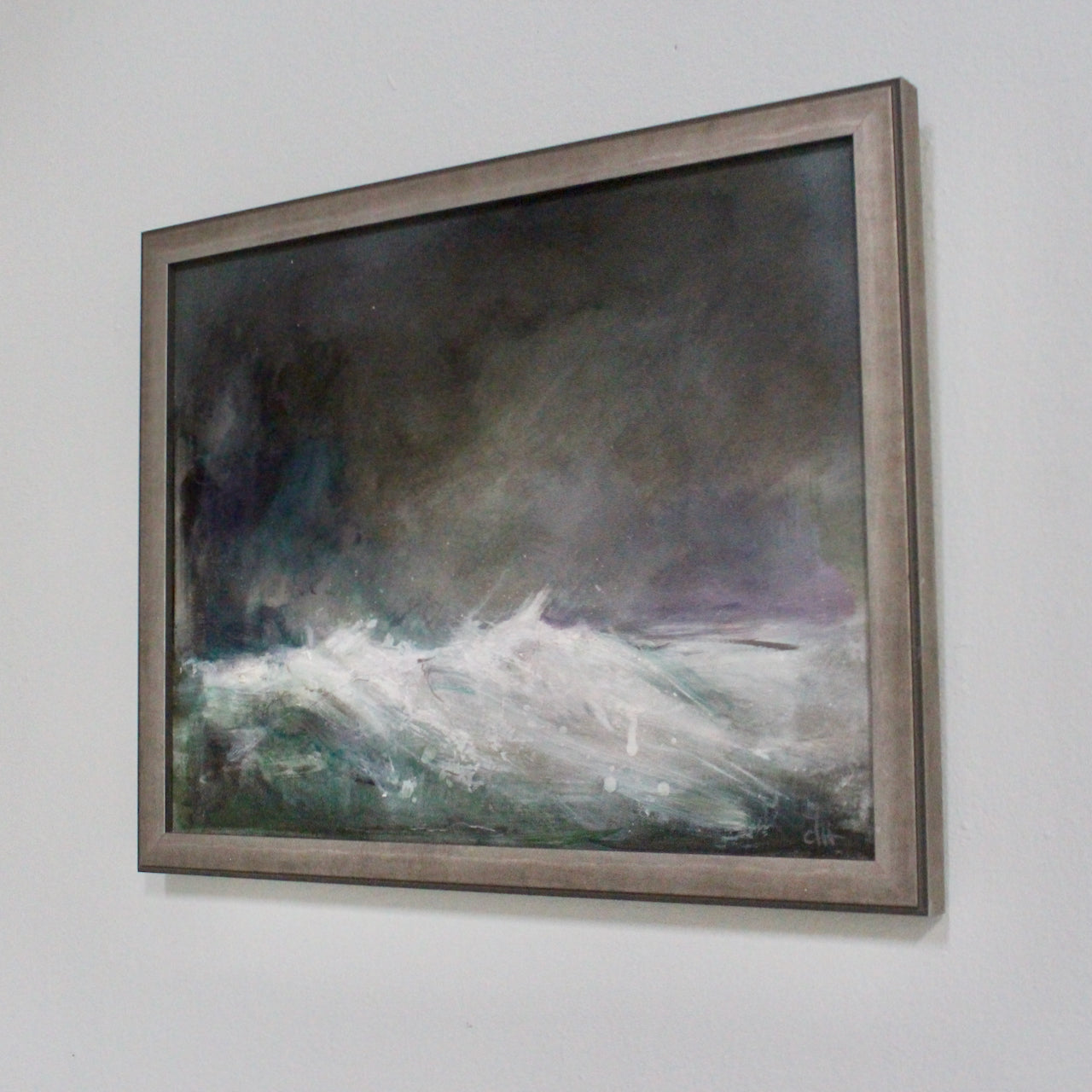 a framed seascape in greys, purples and white by artist Claire Howlett.