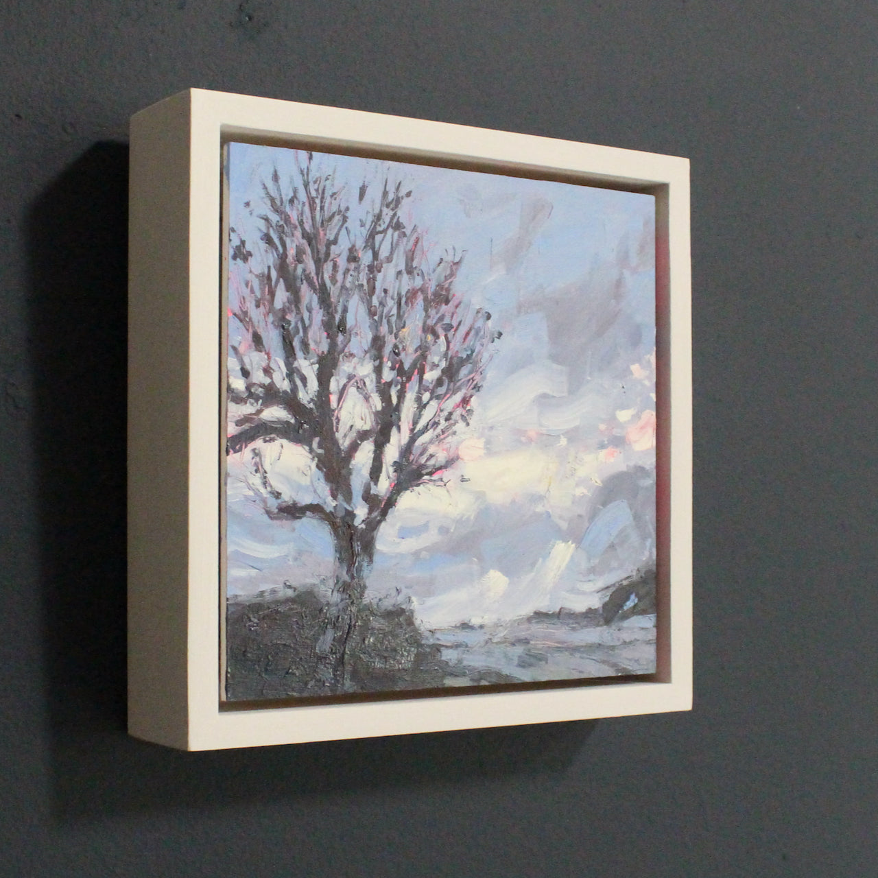 a framed Painting of a bare tree against a blue wintery sky by Cornwall artist Jill Hudson.