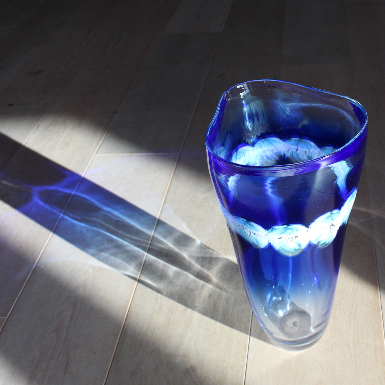 blue handblown glass vase by Benjamin Lintell it was made in Murano, the world famous centre of glass, and the vase includes a detail of white and turquoise murini decoration