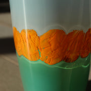 close up detail of a Hand blown glass vase by Murano glass artist Benjamin Lintell in blue, orange and green.