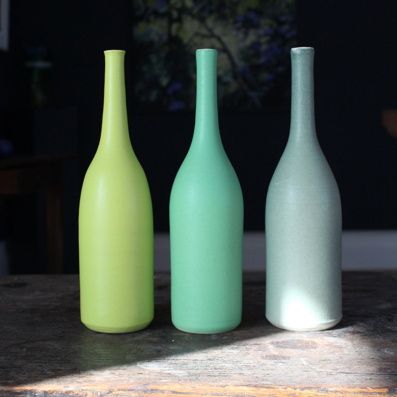 a group of three green ceramic bottles by UK ceramic artist Lucy Burley.