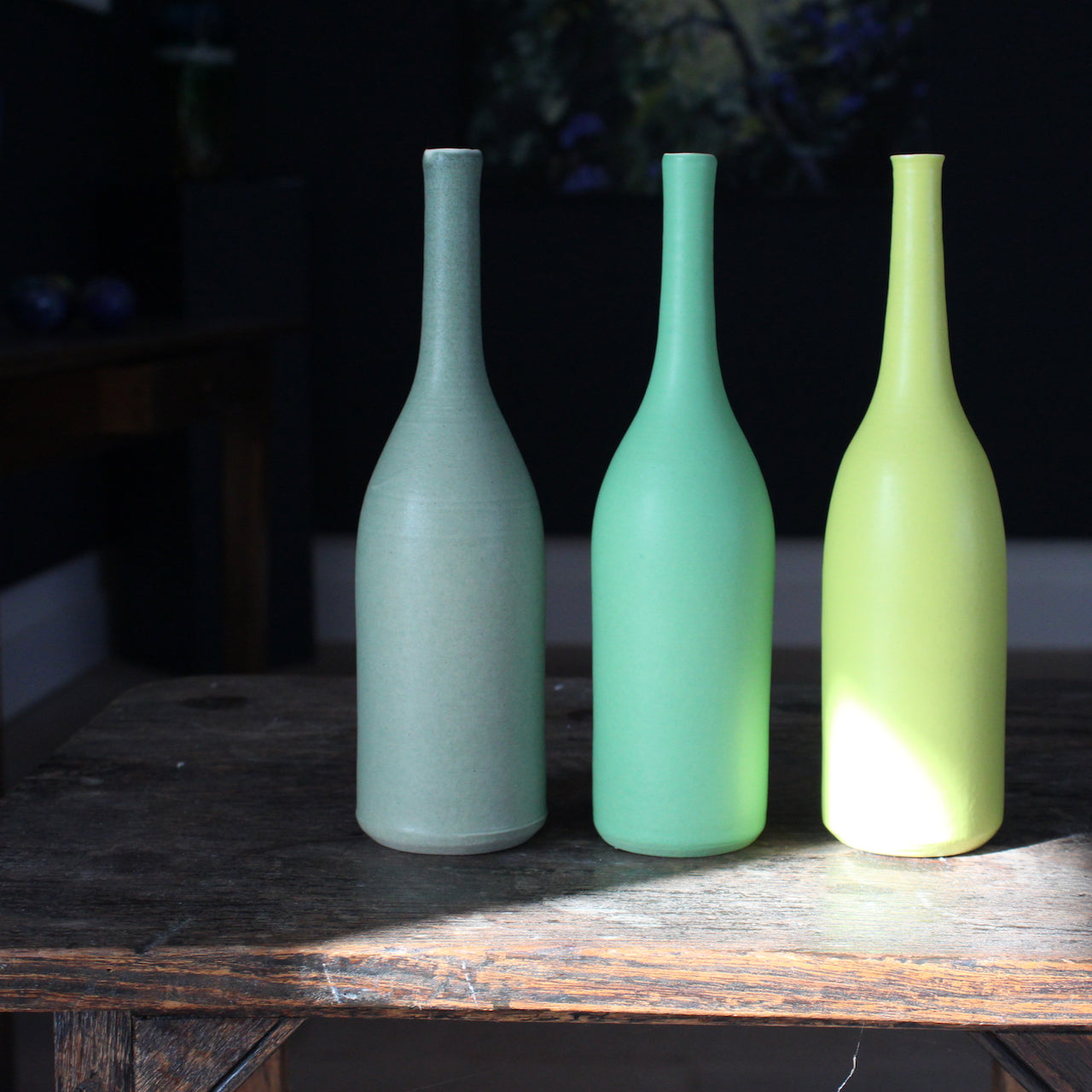 three green ceramic bottles by UK potter Lucy Burley