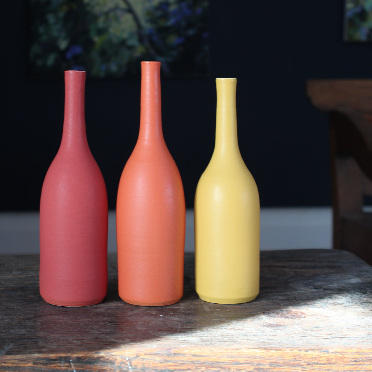 trio of  ceramic bottles in shades of yellow and orange by UK potter Lucy Burley.