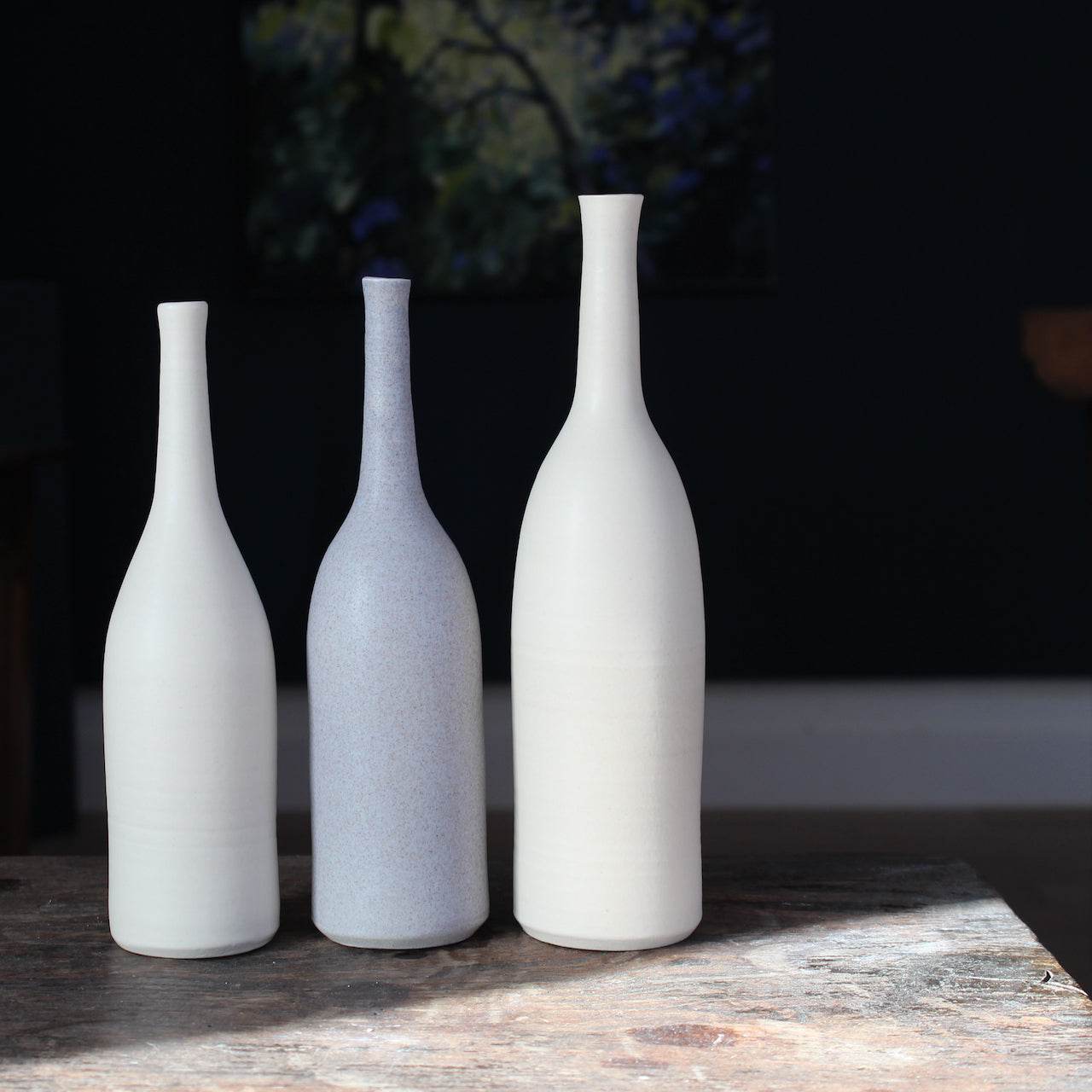 three ceramic bottles in pale, neutral shades by UK ceramicist Lucy Burley.