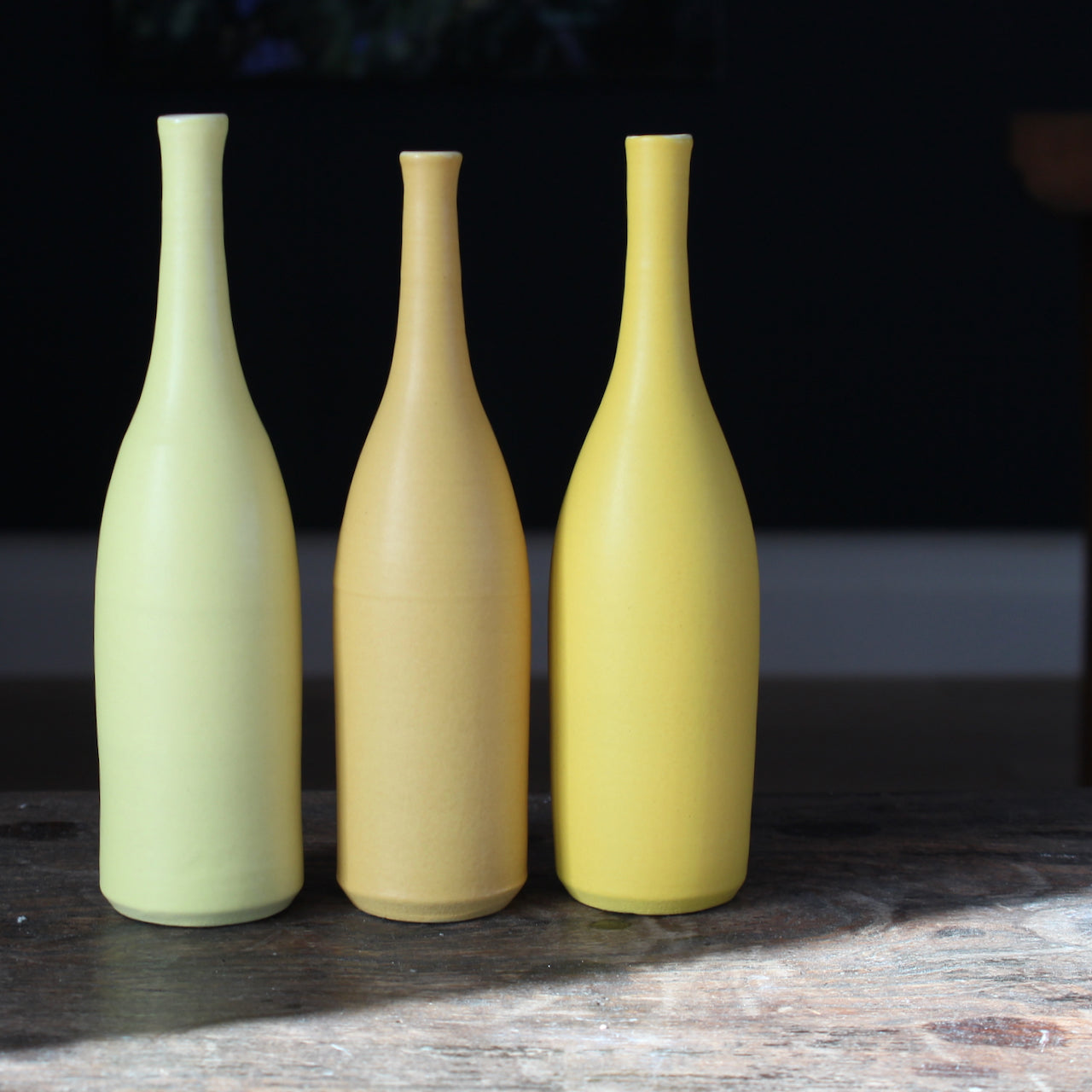 a trio of  ceramic bottles in shades of yellow by UK ceramic artist Lucy Burley