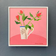 Framed artwork of a mug with red flowers on a pink background, signed 'Sophie Harding'.