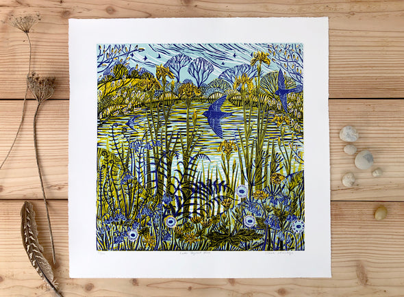 Lino print by artist Claire Armitage with blue and yellow tones of lake, foliage, trees and birds.