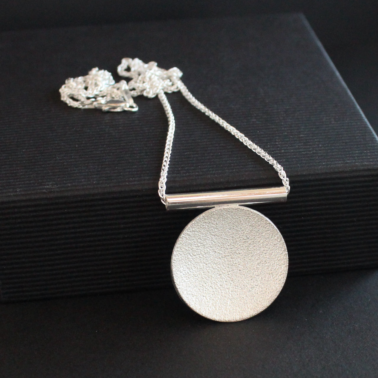 a textured silver round pendant by Beverly Bartlett 