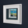 Framed painting of dark wall with recessed window looking out to sea and coastal view by UK artist Philip Lyons.