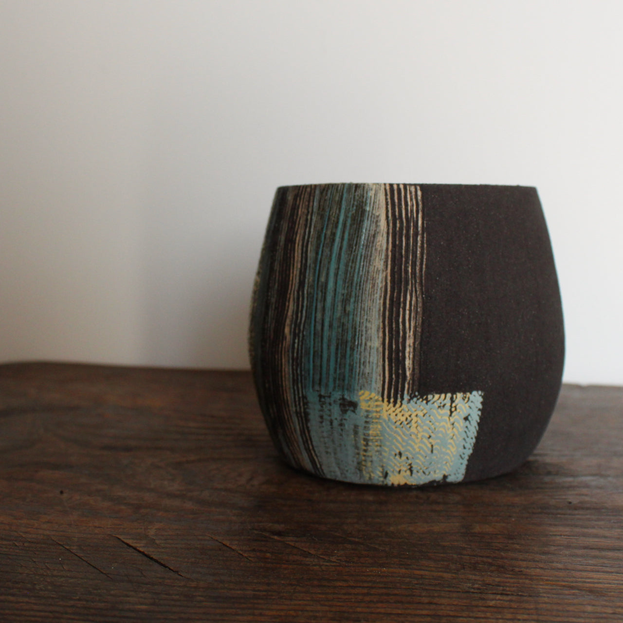 A Ceramic vessel with blue, yellow and white glaze on dark brown clay by Cornish artist Anthea Bowen