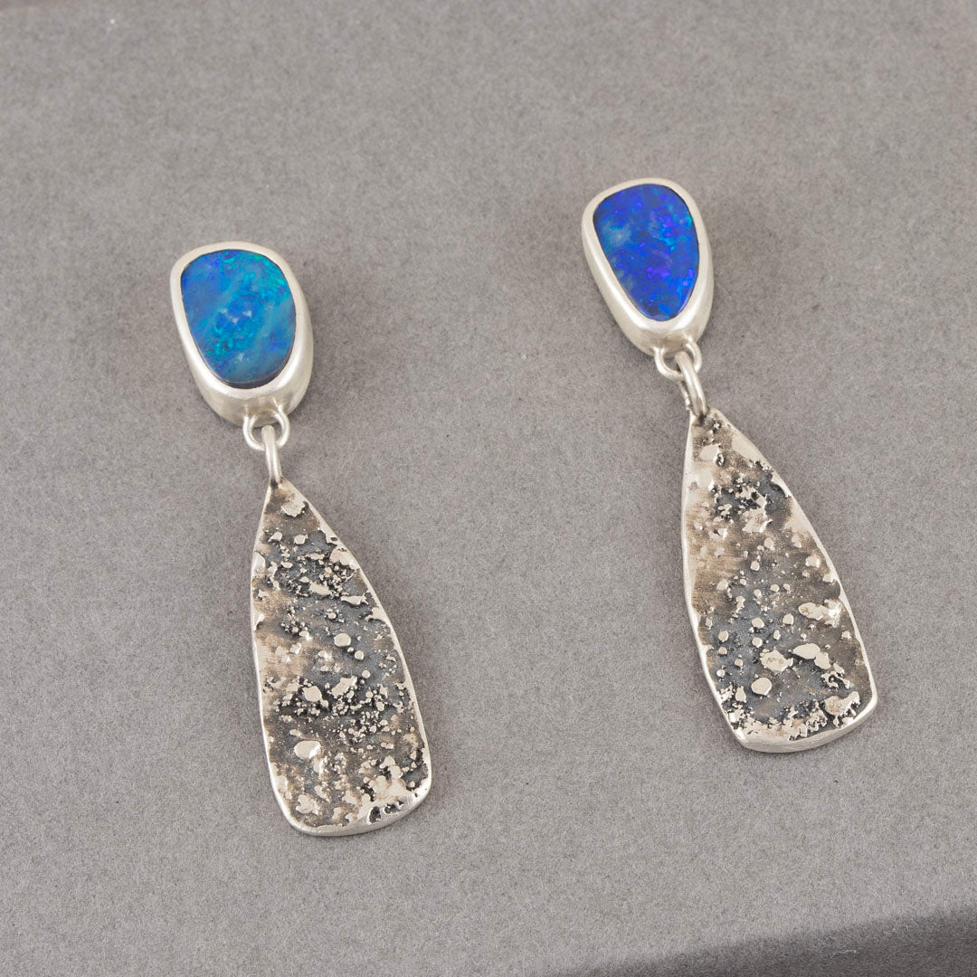 pair of earrings by Carin Lindberg with slightly different blue opals in textured silver setting