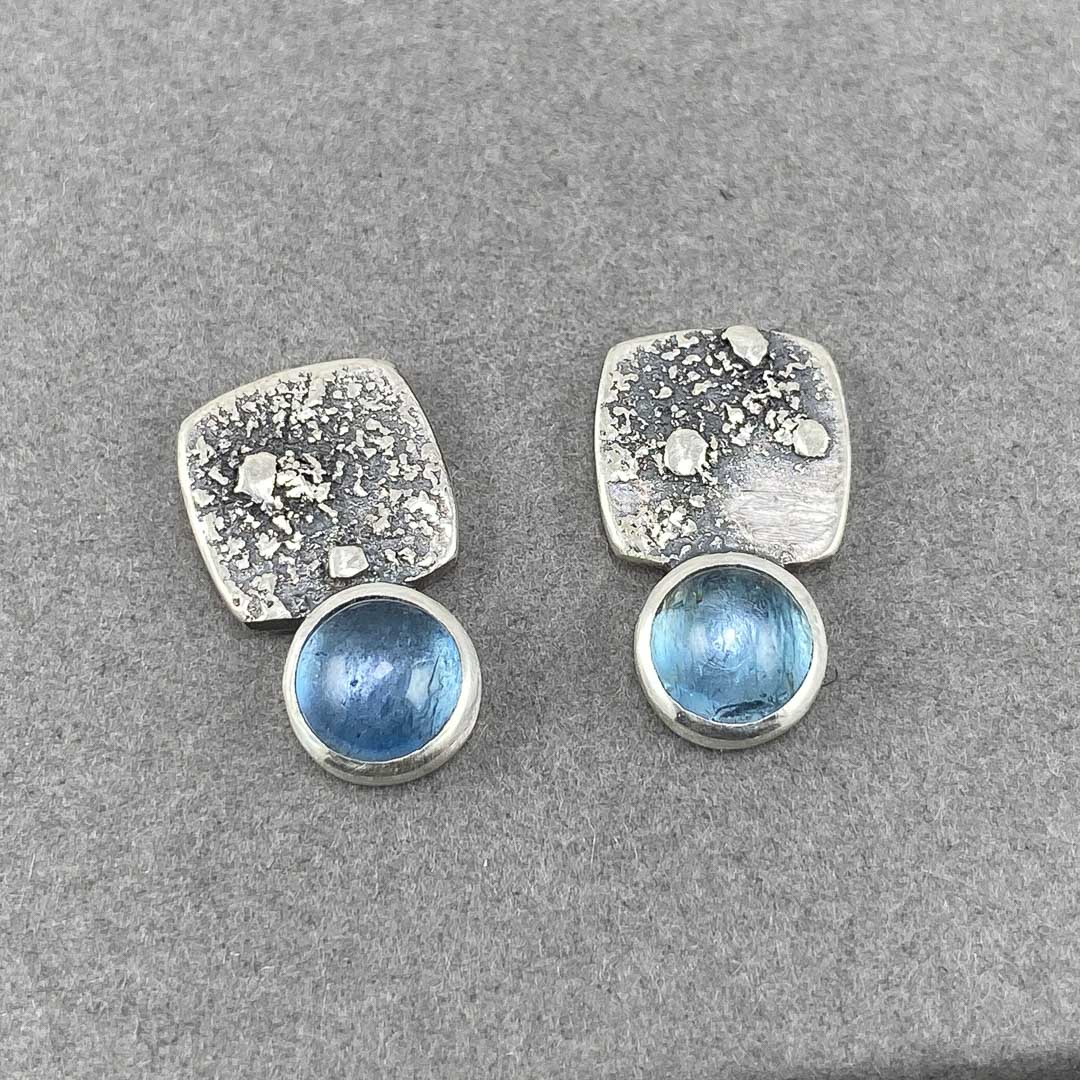 a pair of square textured silver earrings with pale blue stone by UK jewellery designer Carin Lindberg.