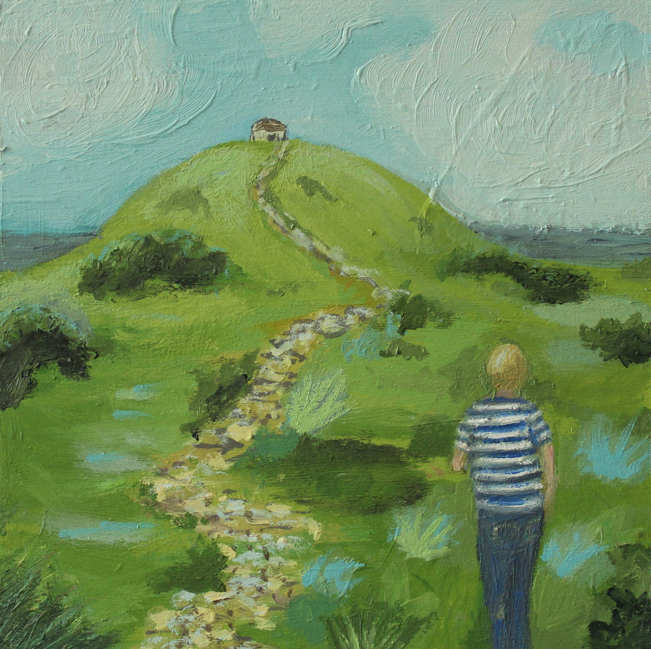 A figure in a stripy blue and white top walking towards a building on top of a hill with a footpath leading to the building by Cornish artist Siobhan Purdy