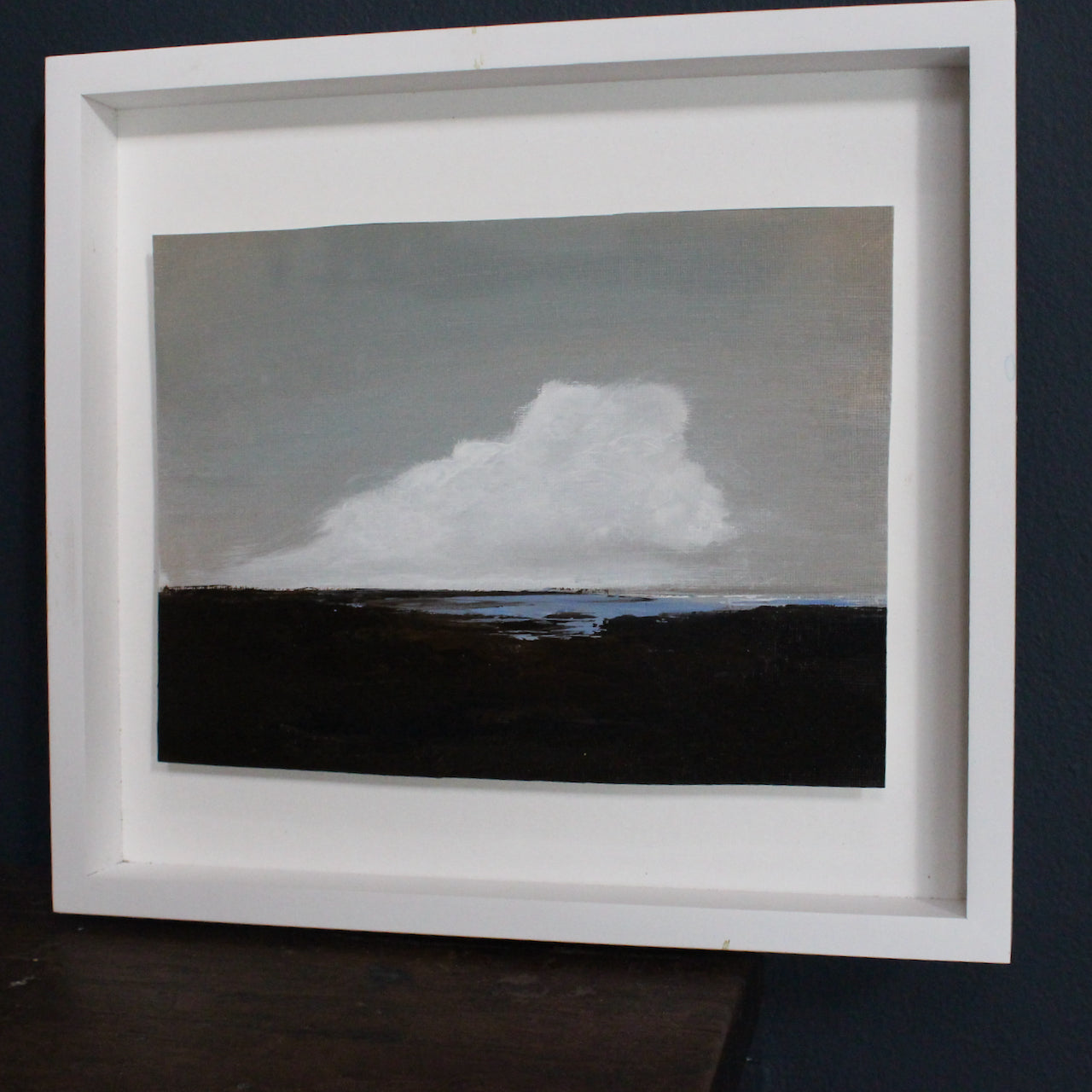 Cornish artist Nicola Mosley seascape of brown and black tones with turquoise ocean and white clouds