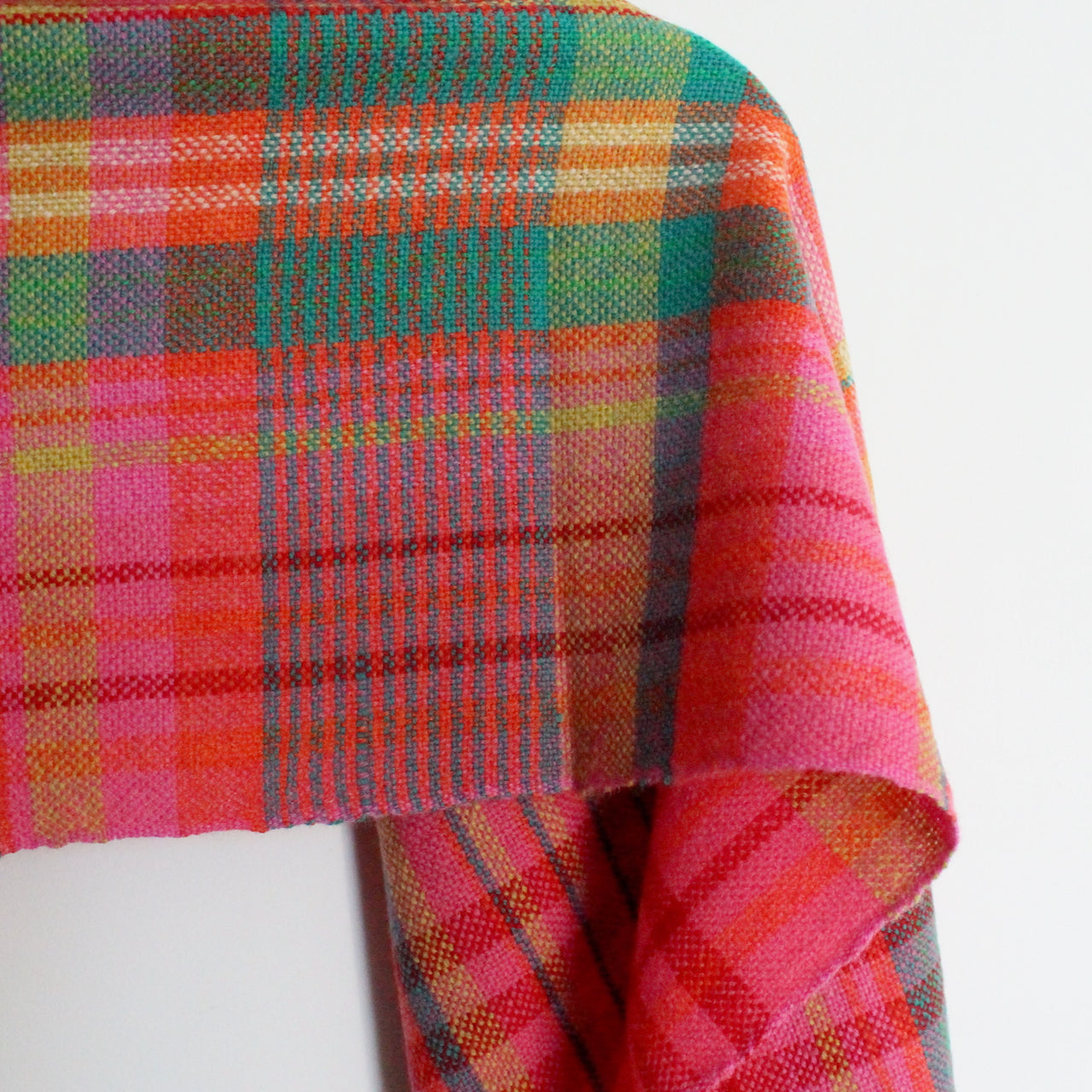 a Teresa Dunne handwoven in Cornwall scarf in pinks, green, reds and yellow.