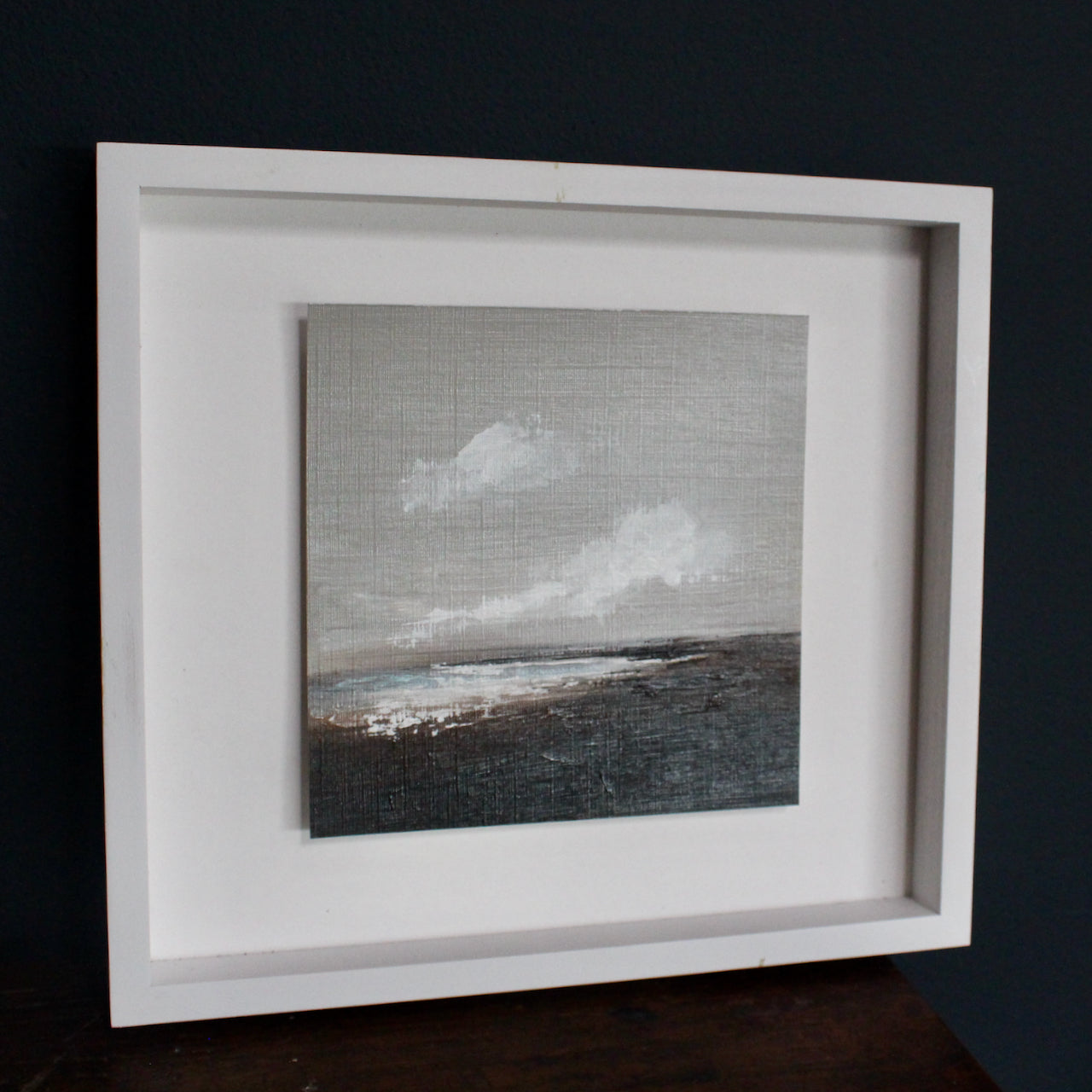 Artist Nicola Mosley seascape of brown and black tones with ocean and white clouds.