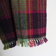 detail of a Teresa Dunne handwoven scarf in green, reds and yellows
