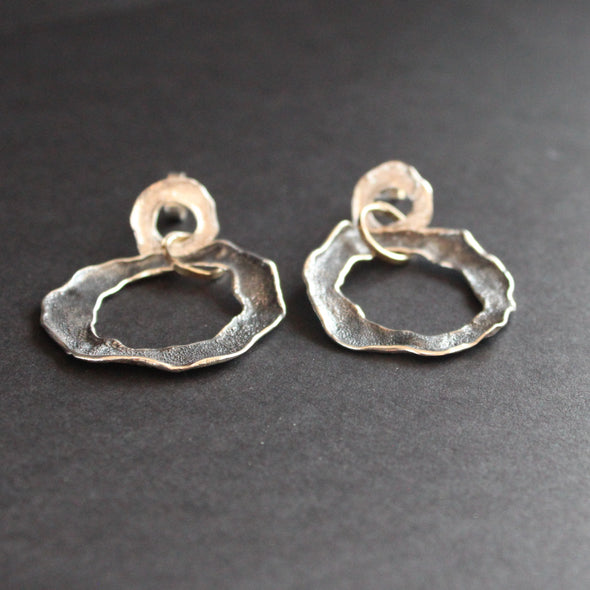 Silver flat circular stud earrings by UK artist Claire Stockings Baker.