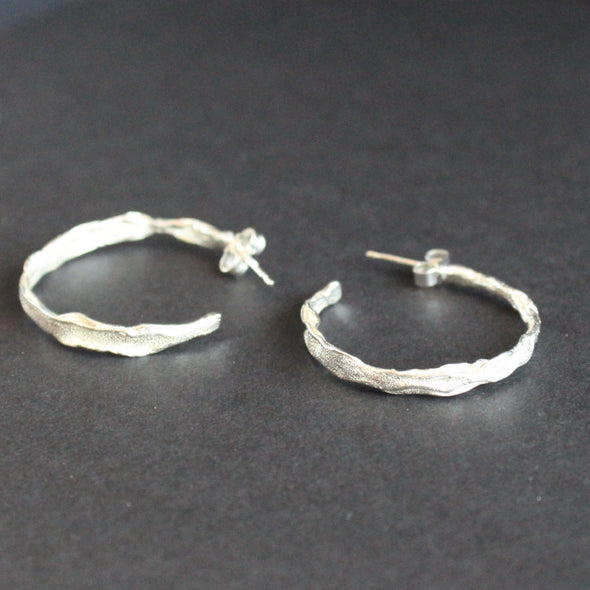 Silver hope earrings with textured surface by Cornish artist Claire Stockings Baker.