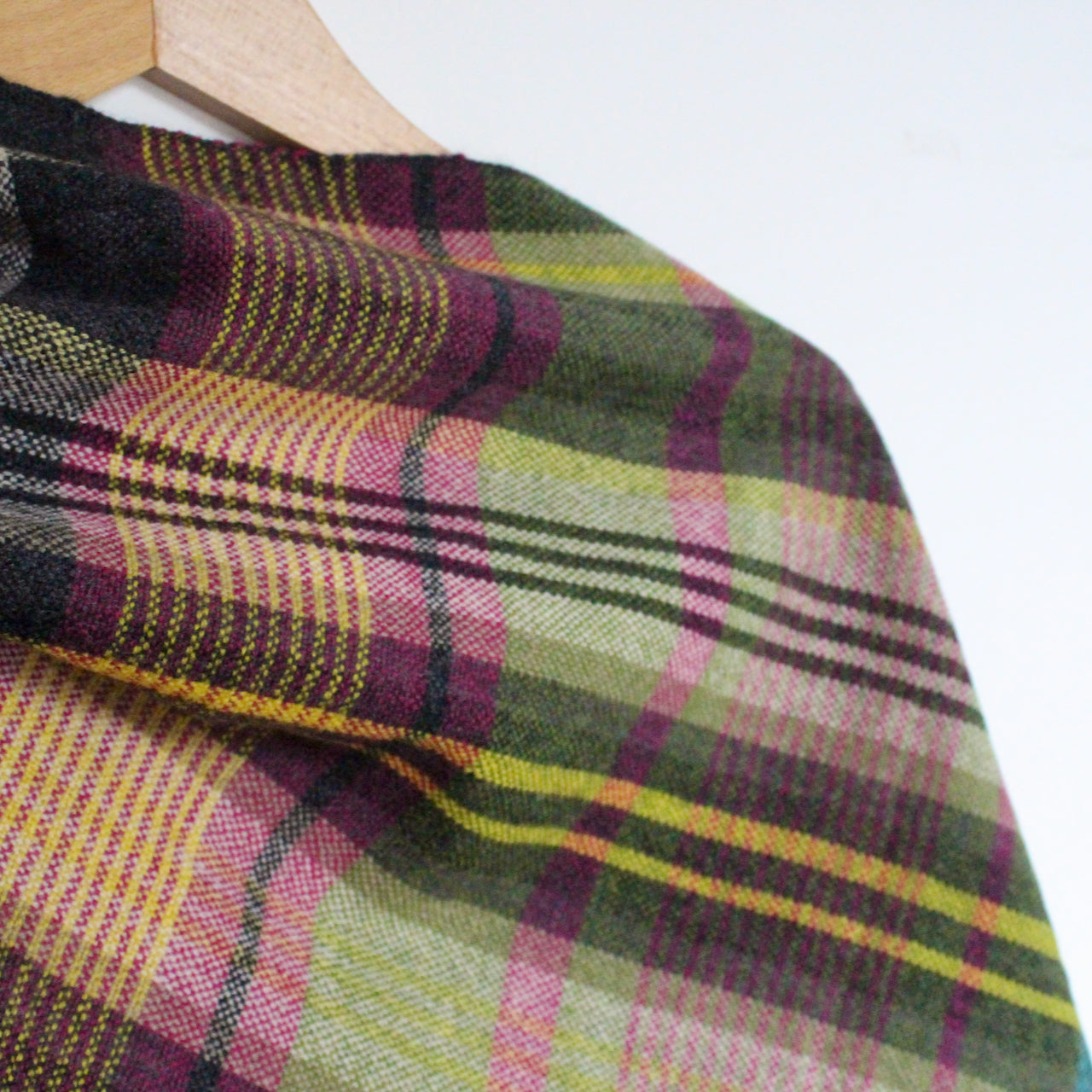 close up detail of a handwoven woollen scarf by Teresa Dunne Cornish textile artist in pink, green, purple and black 