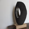 Brown oval sculpture with hollow centre on an oak stand by Cornish artist, Anthea Bowen.