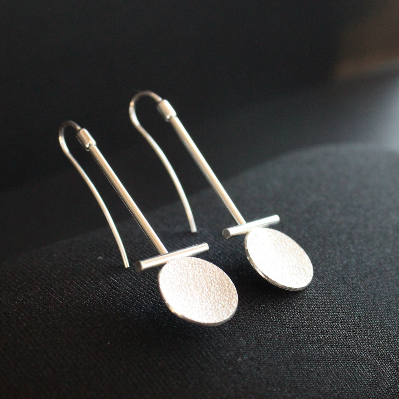 Beverly Bartlett silver drop earrings with a textured silver disc under a silver horizontal bar