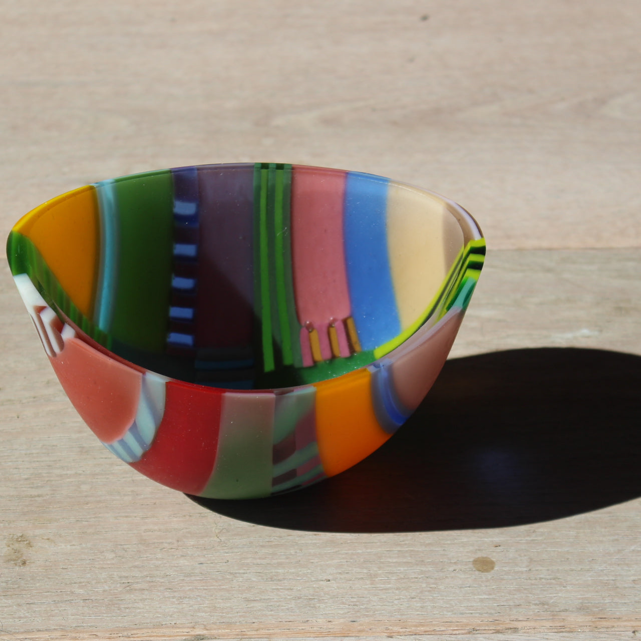 Beautiful vibrant glass bowl by artist Ruth Shelley in tones of pink, green, yellow, blue, red