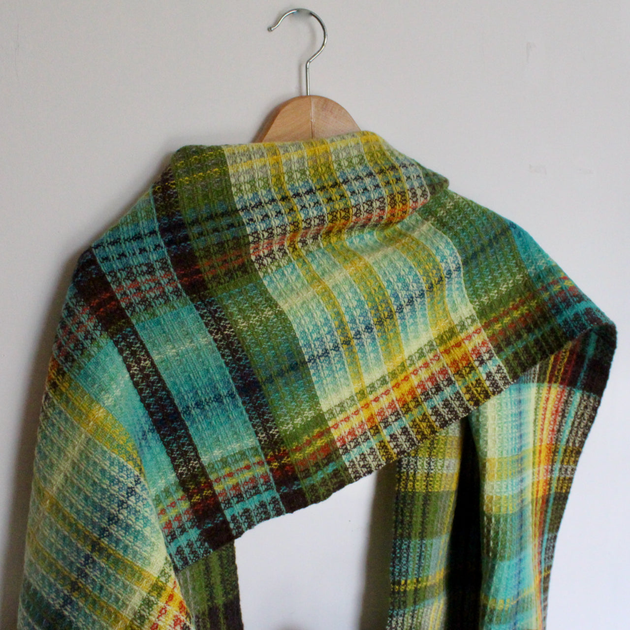 a teresa dunne woollen hand-woven scarf in greens, yellow and black