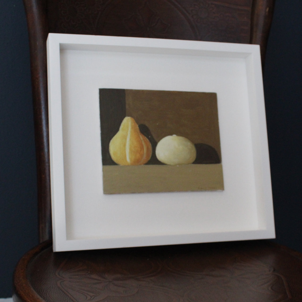 Artist Philip Lyons framed painting of two gourds with shadow with brown background.