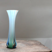a slim and slightly flared multi-coloured glass vase by glass artist Ruth Shelley.