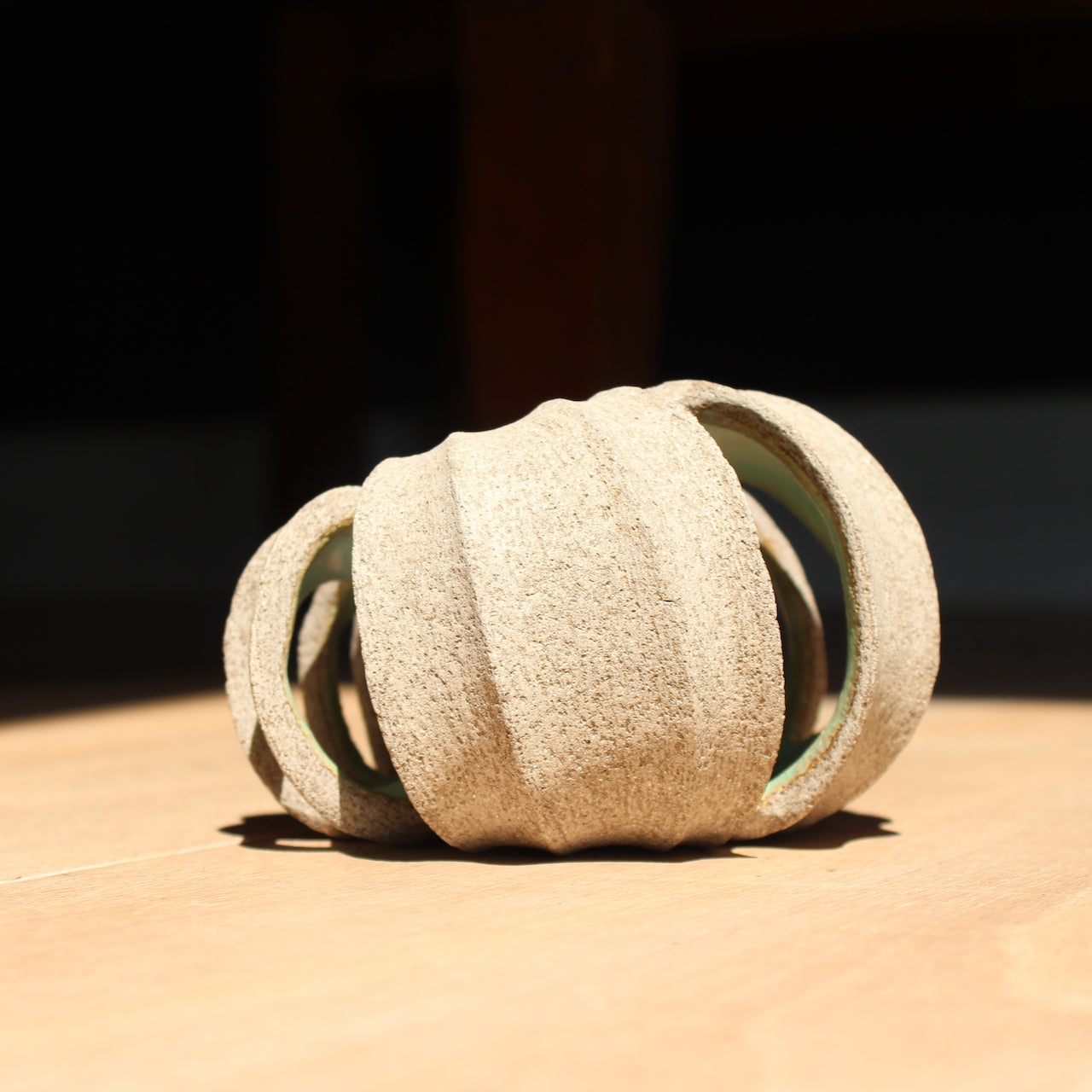 a small rounded stoneware sculpture hand carved with a pale green interior glaze by UK ceramic artist Michele Bianco
