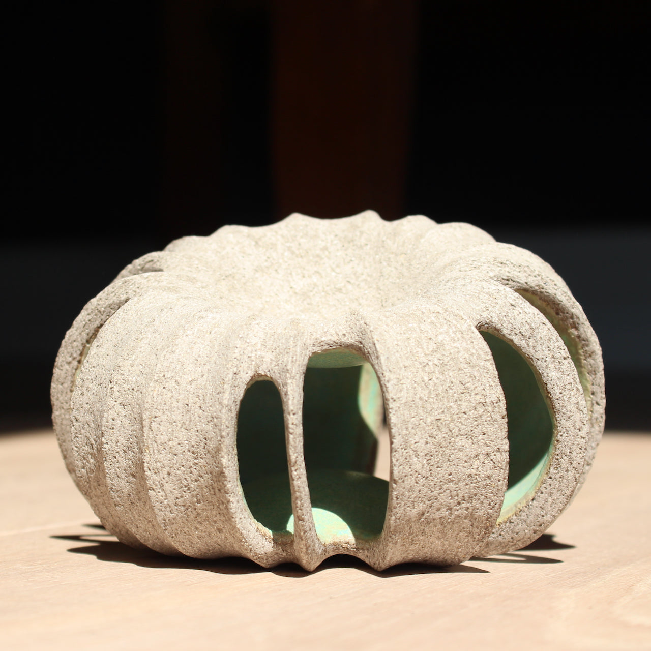 small rounded stoneware sculpture hand carved with a pale green interior glaze by UK ceramic artist Michele Bianco