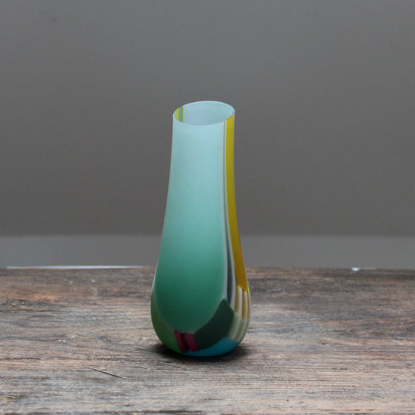 small glass vase in green pinks and yellows with an angled top made by Welsh glass artist Ruth Shelley
