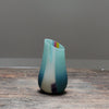 a small glass vase in blue, green and pink with an angled top made by glass artist Ruth Shelley.