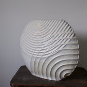 A Michele Bianco pale white stoneware ceramic disc shaped vessel with carved lines. 