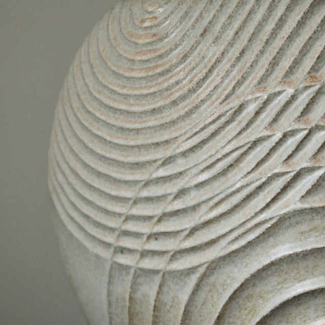 close up of Michele Bianco pale white stoneware ceramic disc shaped vessel with carved overlapping lines. 