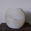 A large white  stoneware ceramic disc shaped vessel with carving detail by Michele Bianco. 