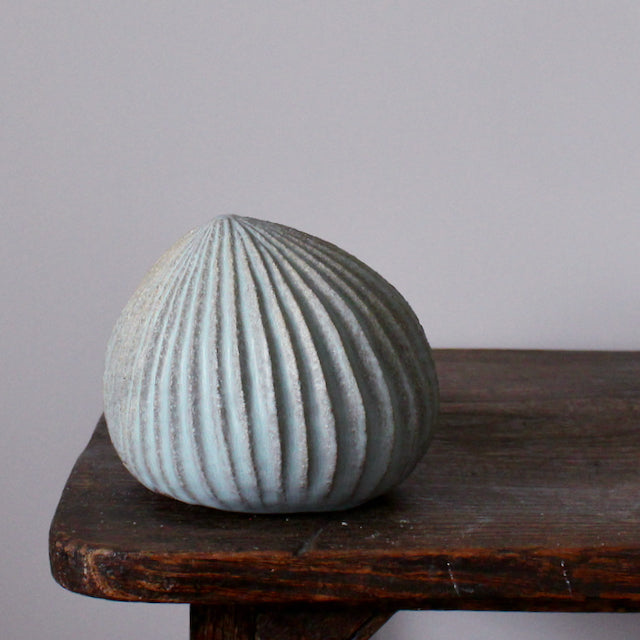 A pale green carved stoneware ceramic pod shaped sculpture by Michele Bianco. 
