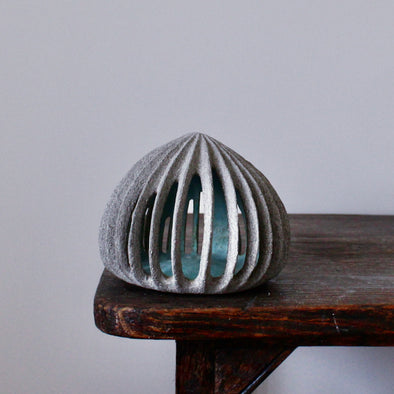 pale green carved and semi open stoneware ceramic pod shaped sculpture by Michele Bianco. 