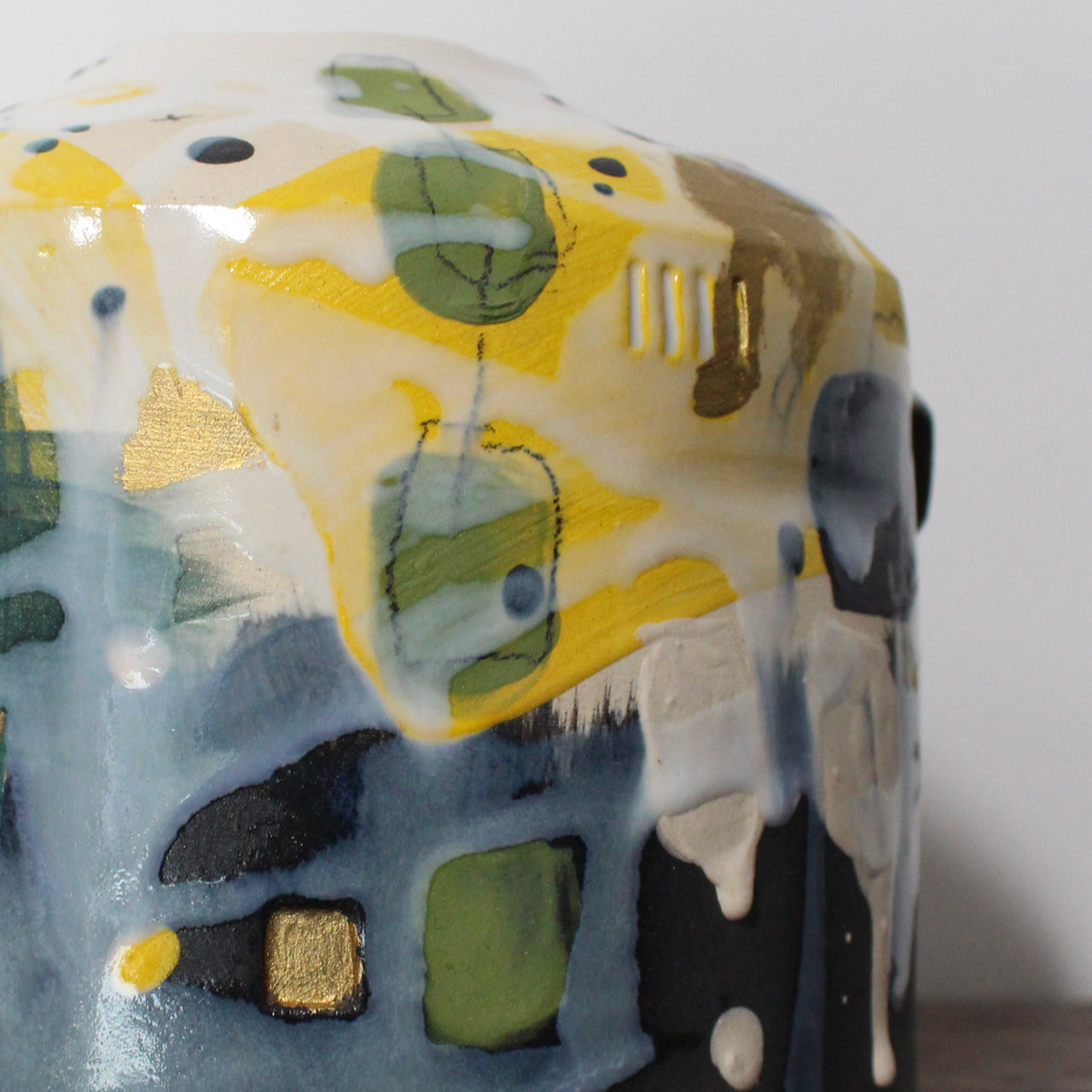 detail of a squat yellow, green and blue ceramic bottle  by Uk ceramicist Dawn Hajittofi